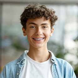 a teenage boy smiling with traditional braces