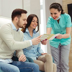 a dentist showing a brochure to a couple