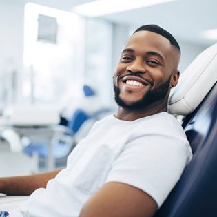 Smiling, relaxed male dental patient in treatment chair