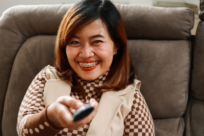 A woman with braces watching TV.