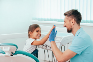 Child and her dentist high-fiving